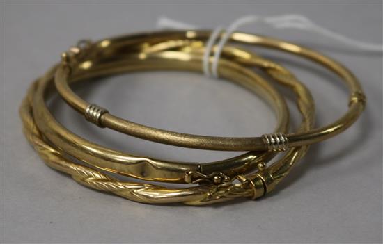 Two 9ct gold hinged bangles and a yellow metal hinged bangle.